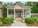 Charming front porch featuring classic columns, a cozy seating area, and a welcoming blue front door at 2646 N Olivers Cross Rd, Newton, NC 28658