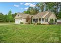 Inviting front yard featuring a lush green lawn, colorful landscaping, and a charming front porch at 2646 N Olivers Cross Rd, Newton, NC 28658