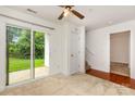 Bright living room featuring neutral carpet, a sliding glass door, and a fan at 3158 Walnut Park Dr, Charlotte, NC 28262