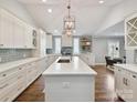 Bright, spacious kitchen with white cabinets, a large island, stainless steel appliances, and hardwood floors at 335 Greystone Rd, Charlotte, NC 28209