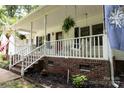 Inviting front porch features white railings, swing, and lush hanging plants at 432 Partridge Pl, York, SC 29745