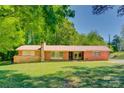 Charming single-story brick home featuring a well-manicured lawn and a classic design with brick and stone accents at 6447 E Nc 27 Hwy, Iron Station, NC 28080