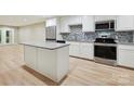 Modern kitchen features stainless steel appliances, granite countertops, and light wood flooring at 7004 Quail Hill Rd, Charlotte, NC 28210