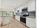 Modern kitchen features stainless steel appliances, granite countertops, and light wood flooring at 7004 Quail Hill Rd, Charlotte, NC 28210