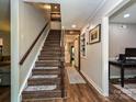 Hallway featuring hardwood floors and a staircase with natural wood handrail at 8200 Lansford Rd, Charlotte, NC 28277