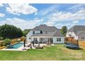 Stunning backyard with in-ground pool, lounging area, outdoor seating, and well-maintained lawn at 959 Robinson Rd, Gastonia, NC 28056