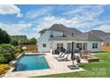Gorgeous backyard featuring a pool, outdoor seating, lounge chairs, and spacious lawn at 959 Robinson Rd, Gastonia, NC 28056