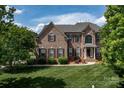 Traditional two-story brick home with manicured lawn and shuttered windows at 1116 Crooked River Dr, Waxhaw, NC 28173