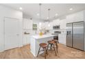 A modern kitchen with white cabinets, stainless steel appliances, and stylish pendant lighting at 1148 Thayer Glen Ct, Charlotte, NC 28213