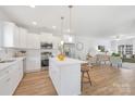 Open-concept kitchen with an island that offers seating and flows into the dining and living areas at 1148 Thayer Glen Ct, Charlotte, NC 28213