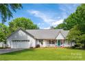 Charming home featuring a well-manicured lawn, a blue door, and an attached two-car garage at 1666 Sam Smith Rd, Fort Mill, SC 29708