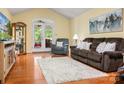 Inviting living room with hardwood floors, a neutral rug, and a comfortable brown sofa near the French doors at 1666 Sam Smith Rd, Fort Mill, SC 29708