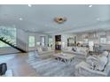 Open-concept living room with hardwood floors, modern staircase, and view into kitchen at 1919 Shoreham Dr, Charlotte, NC 28211