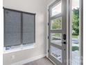 Modern front door with glass inserts and gray trim, complemented by a roller shade covered window at 2006 Upstate Way, Charlotte, NC 28206