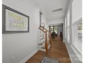 Bright hallway with hardwood floors and stairs leading to the upper level, filled with natural light at 2034 Suttonview Rd, Fort Mill, SC 29708