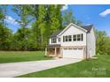 Charming two-story home featuring a brick and white exterior, attached garage, and a well-manicured lawn at 5115 Carden Dr, Charlotte, NC 28227