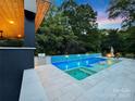 Gorgeous pool and spa featuring built-in grill, lounge seating, and immaculate tile work at 6508 Trenton Pl, Charlotte, NC 28226