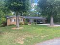Charming brick home with a spacious carport framed by mature shade trees and a front lawn at 734 Harris Nw St, Concord, NC 28025
