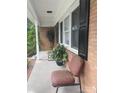 Inviting brick front porch with comfortable seating and lush potted plants enhancing the entrance at 734 Harris Nw St, Concord, NC 28025
