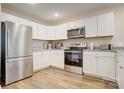 Bright kitchen featuring white cabinetry, granite countertops, and stainless steel appliances with modern fixtures at 809 Fisher St, Kannapolis, NC 28027
