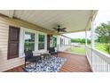 Inviting covered porch with ceiling fan, chairs, and outdoor rug at 8140 Karriker Rd, Kannapolis, NC 28081