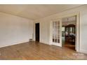 Open living area with hardwood floors and glass-paned doors leading to the dining room at 114 S 5Th St, Albemarle, NC 28001