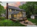 Rear exterior view featuring a screened porch, fire pit and wooded lot at 121 Northampton Dr, Mooresville, NC 28117