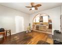 Spacious living room featuring hardwood floors, ceiling fan, and archway into the kitchen at 1221 Patterson St, Shelby, NC 28152