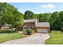 Two-story brick house with black shutters, attached garage and neatly kept lawn at 16565 Kimbolten Dr, Huntersville, NC 28078