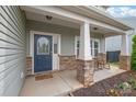 Cozy front porch with rocking chairs and stone-clad columns, leading to a blue front door at 306 Fesperman Cir, Troutman, NC 28166