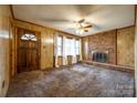 Spacious living room with a brick fireplace, wood paneling, and a bright window view at 3491 Mcconnells Hwy, Rock Hill, SC 29732
