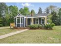 Charming home with navy blue siding, a front porch, and a well-maintained lawn at 410 E 17Th St, Kannapolis, NC 28083