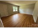 Bright living room featuring gleaming hardwood floors, neutral walls, and a window offering plenty of natural light at 5008 Delivau Dr, Charlotte, NC 28215
