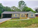 The front of the home boasts new gravel driveway, a carport, a covered front porch, and updated exterior paint at 501 N Hawthorne St, Mount Holly, NC 28120