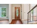Inviting entryway featuring a decorative wood door, hardwood floors, and staircase access at 6807 Woodfield Dr, Charlotte, NC 28215