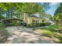 View of the house with a long driveway and a metal carport on the side at 6807 Woodfield Dr, Charlotte, NC 28215
