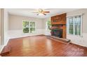 Bright living room featuring a cozy fireplace, hardwood floors, and large windows at 6807 Woodfield Dr, Charlotte, NC 28215