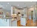 Bright kitchen featuring white cabinetry, granite countertops, stainless steel appliances, and hardwood floors, perfect for culinary enthusiasts at 7471 Barfield Ln, Denver, NC 28037
