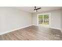 Bright bedroom featuring wood-look floors and sliding glass doors to outdoor space at 8325 Knights Bridge Rd, Charlotte, NC 28210