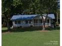 Charming single-story home with a blue metal roof and a well-manicured lawn at , Salisbury, NC 28147