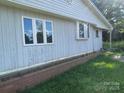 View of the exterior showing a white siding wall, multiple windows, and a brick planter box at , Salisbury, NC 28147