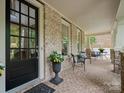Relaxing covered back porch with brick flooring and comfortable seating, perfect for outdoor living at 1030 Westbury Dr, Matthews, NC 28104