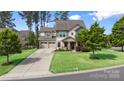 Beautiful home with a well-manicured lawn, long driveway, and mature trees under a blue sky at 106 Sweet Briar Dr, Fort Mill, SC 29707