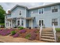 Charming townhome featuring blue siding, well-manicured landscaping, and a welcoming front porch at 1404 River Dr, Belmont, NC 28012