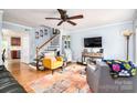 Cozy living room with hardwood floors, a ceiling fan, comfortable seating, and a staircase at 1404 River Dr, Belmont, NC 28012