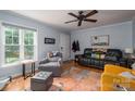 Comfortable living room with a leather sofa, a patterned rug, and a large window at 1404 River Dr, Belmont, NC 28012