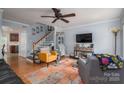 Inviting living room with hardwood floors, a ceiling fan, and a staircase with white railings at 1404 River Dr, Belmont, NC 28012