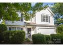 Two-story home features white siding, dark shutters, a two-car garage, and mature landscaping at 14311 Riding Hill Ave, Charlotte, NC 28213