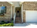 Close up view of a front door with brick steps leading to a one car attached garage at 1680 Beleek Ridge Ln, Clover, SC 29710