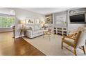 Cozy living room featuring hardwood floors, neutral walls, built-in shelving, and a comfortable seating arrangement at 1714 Edgewater Dr, Charlotte, NC 28210